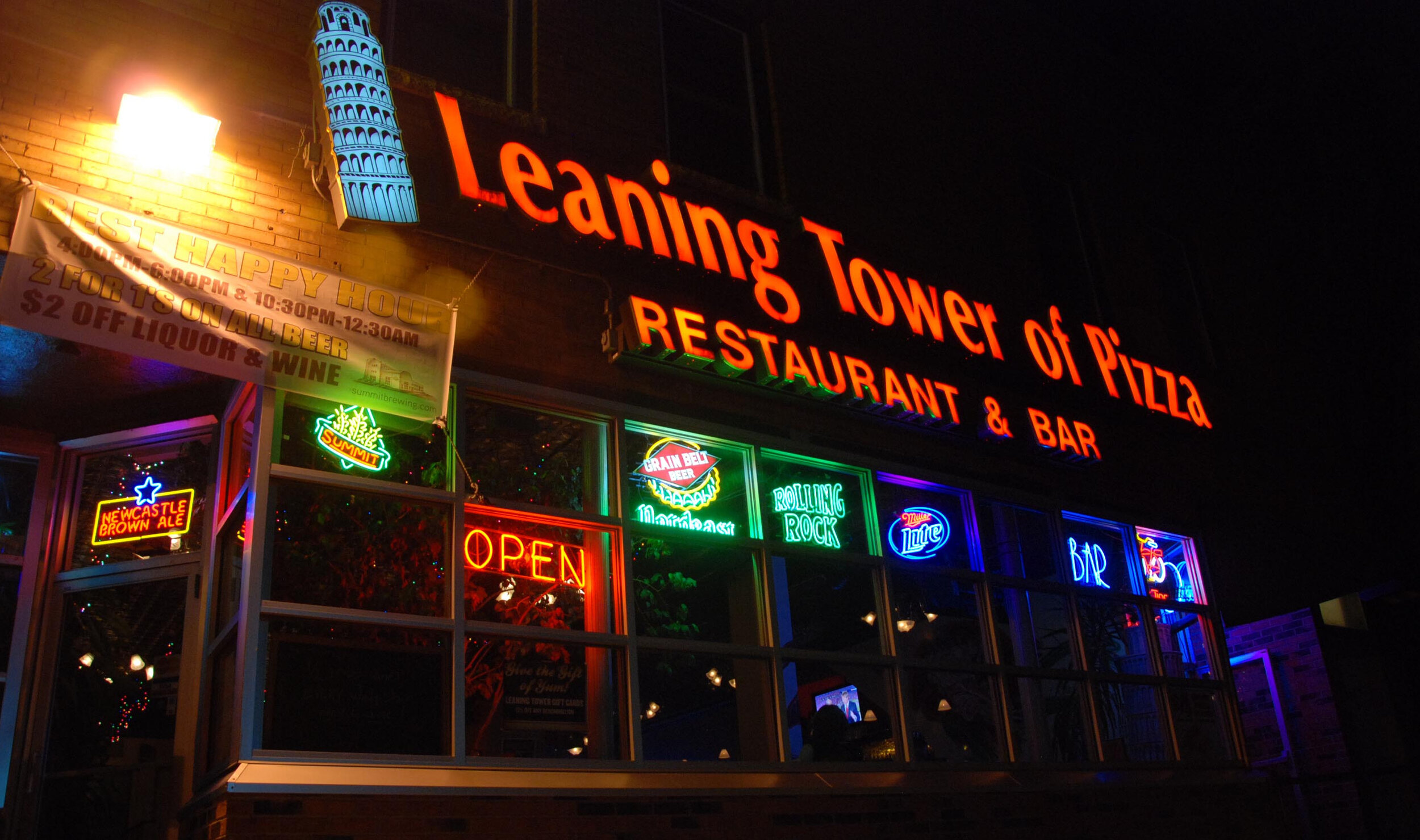 the Leaning Tower of Pizza storefront lit up at night